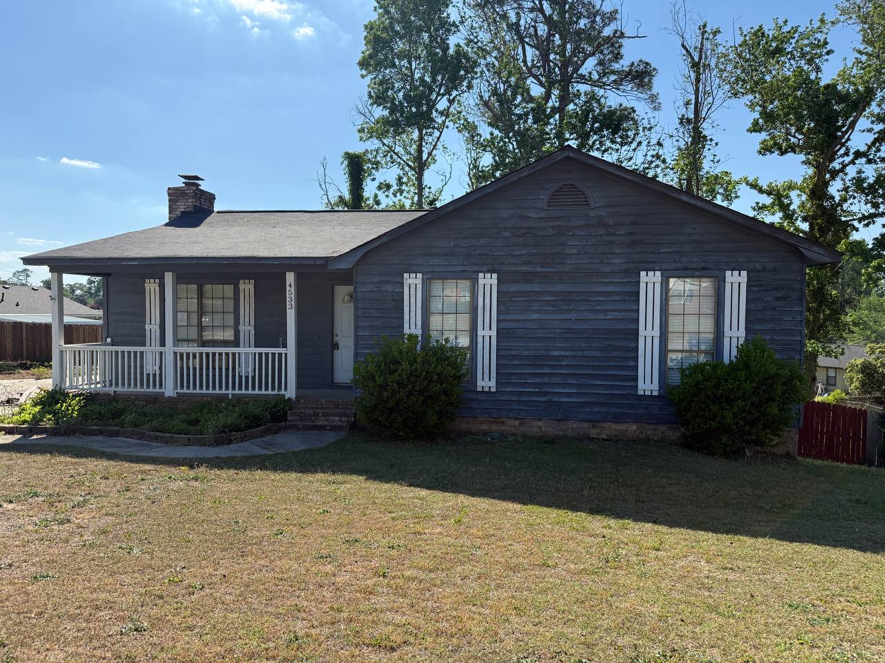Single-story home with covered front porch and white railing purchased as-is